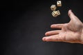 Hand throwing dice in front of a dark background Royalty Free Stock Photo