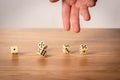 Hand throwing five dice on a wooden table Royalty Free Stock Photo