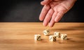 Hand throwing five dice on a wooden table Royalty Free Stock Photo