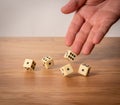 Hand throwing five dice on a wooden table Royalty Free Stock Photo