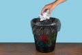 Hand throwing out paper into a trash basket Royalty Free Stock Photo