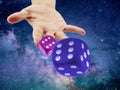 Hand Throwing or rolling Dice in the cosmo or universe. Causality or randomness concept Royalty Free Stock Photo