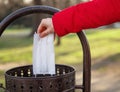 Hand throwing a surgical mask into the bin in the park Royalty Free Stock Photo