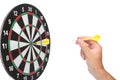 Hand throwing a yellow dart Royalty Free Stock Photo