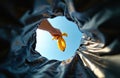 Hand throws banana peel into garbage bin. View from inside garbage bag, sky background. Waste sorting, disposal, recycling Royalty Free Stock Photo