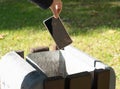Hand Throws out Smartphone Garbage, Throwing Smartphone into Street Trash Can, Dangerous Garbage Concept Royalty Free Stock Photo
