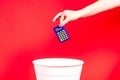 A hand throws a tax calculator into trash. The calculator is thrown into the office wastebasket. Royalty Free Stock Photo