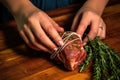 hand tightening string around rotating spiced lamb leg