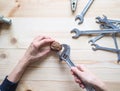 Hand, tool and big walnut on wooden background. The concept of complex problems, the challenge can be solved. Royalty Free Stock Photo