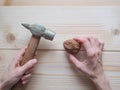 Hand, tool and big walnut on wooden background. The concept of complex problems, the challenge can be solved. Royalty Free Stock Photo