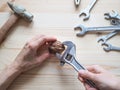 Hand, tool and big walnut on wooden background. The concept of complex problems, the challenge can be solved. Royalty Free Stock Photo