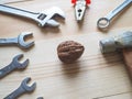 Hand, tool and big walnut on wooden background. The concept of complex problems, the challenge can be solved. Royalty Free Stock Photo