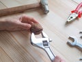 Hand, tool and big walnut on wooden background. The concept of complex problems, the challenge can be solved. Royalty Free Stock Photo