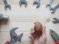 Hand, tool and big walnut on wooden background. The concept of complex problems, the challenge can be solved. Royalty Free Stock Photo