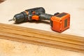 Electric drill,screwdriver on a plywood wooden surface with sawdust in workshop Royalty Free Stock Photo