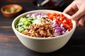 hand topping bbq pulled pork bowl with diced onions Royalty Free Stock Photo