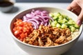 hand topping bbq pulled pork bowl with diced onions Royalty Free Stock Photo