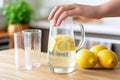 hand topping up a pitcher of lemonade with soda water