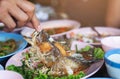 Hand touches the fish on a dish waste food after eating a Cooked Fish, unclean Royalty Free Stock Photo