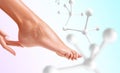 Hand touches foot near white molecules.