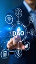 Hand touching DAO decentralized autonomous organization symbol on a futuristic digital network interface. Royalty Free Stock Photo