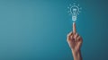 A hand touching a drawn lightbulb symbolizing an idea on a teal background.. AI generated Royalty Free Stock Photo