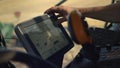 Hand touching harvester monitor closeup. Tractor driver working grain field