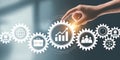 Hand touching interconnected gears with business icons and graph image Royalty Free Stock Photo