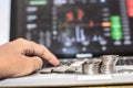 Hand touching keyboard and coin with monitor shows trading traffic, Bitcoin minning