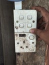 Hand touching old electrical switch box on wooden wall Royalty Free Stock Photo