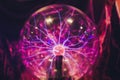 Hand touching a plasma ball with smooth magenta-blue flames. Royalty Free Stock Photo