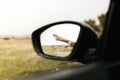 Hand touching rain drops. Mirror seen through the glass. Wet car window. Close up rain drop. Car view see the mirror. Rainy day Royalty Free Stock Photo