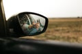 Hand touching rain drops. Mirror seen through the glass. Wet car window. Close up rain drop. Car view see the mirror. Rainy day Royalty Free Stock Photo