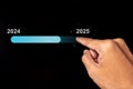 Hand touching virtual status bar to change from 2024 to 2025. Turn of the new year. New year's resolution Royalty Free Stock Photo