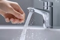 A hand touching the water coming out of a tap in a sink. Royalty Free Stock Photo