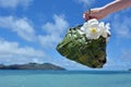 Hand of a tourist woman carry a Fijian basket made out of coconut tree leaves