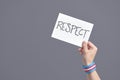 Hand with a transgender flag bracelet holding a paper with a message: respect Royalty Free Stock Photo