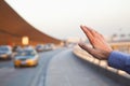 Hand of traveler hailing a taxi outside of the airport Royalty Free Stock Photo