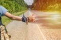 Hand Traveler hitchhiking. Young guy stops passing trucks on the highway. Summer time. Hitchhiking concept