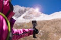 Hand traveler woman holding action camera at snow mountain,Navigation for travel,Close up