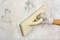 Hand with trowel plastering and smoothing wall Royalty Free Stock Photo