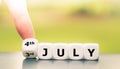 Hand tuns dice and changes the date `3rd of July` to `4th of July`. Royalty Free Stock Photo