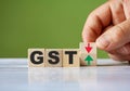 The hand turn wooden block with red and green arrow as change concept of GST. Word GST conceptual symbol Royalty Free Stock Photo