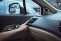 Hand turning on car air conditioning system beacuse raining cold weather,Button on dashboard in car panel Royalty Free Stock Photo