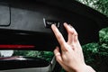 Hand turning car trunk electric lock button.