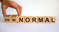 Hand is turning cubes and changes the words `new normal` to `next normal`. Covid-19 postpandemic concept. Beautiful white Royalty Free Stock Photo