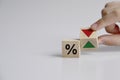 Hand is turning a dice and changes the direction of an arrow symbolizing that the interest rates are going down Royalty Free Stock Photo