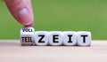 Hand is turning a dice and changes the German word `VOLLZEIT` to `TEILZEIT`.