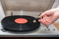 Hand turning on stereo turntable analog retro vintage. An old-fashioned plastic turntable playing a music track Royalty Free Stock Photo