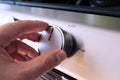 Hand turning a stove oven knob
